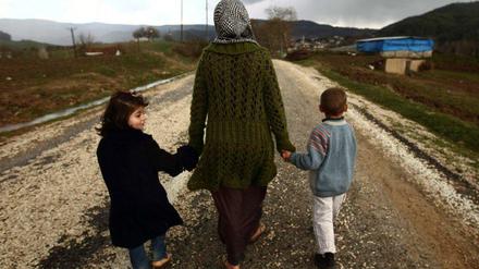 Diese Frau ist aus Syrien in die Türkei geflohen. Im Grenzgebiet lebt sie nun mit ihren zwei Kindern in einem Flüchtlingslager.