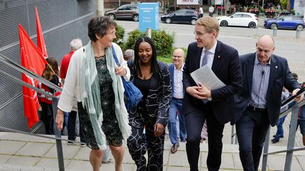 Monika Heinold und Aminata Touré von den Grünen gehen gemeinsam mit Daniel Günther (CDU) eine Treppe hinauf. 