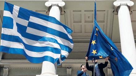 Die Flagge der EU wird neben der griechischen Flagge gehisst.