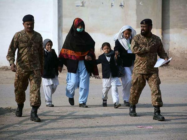 Soldaten bringen Kinder und Lehrer in Sicherheit.