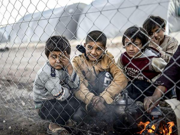 Kurdische Kinder versammeln sich an einer Feuerstelle im türkischen Flüchtlingslager Suruc