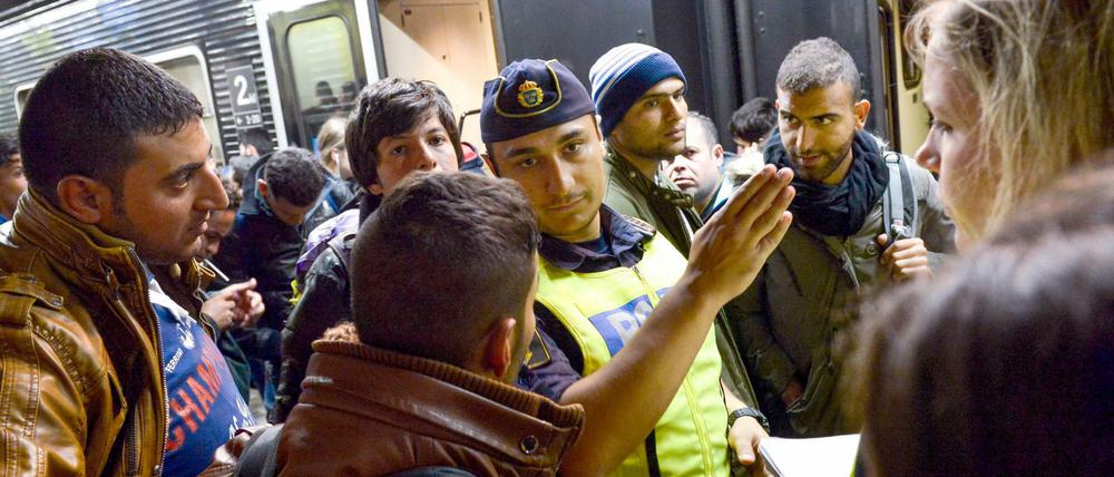 Ein Polizist mit Flüchtlingen am Bahnhof in Stockholm (Archivbild).