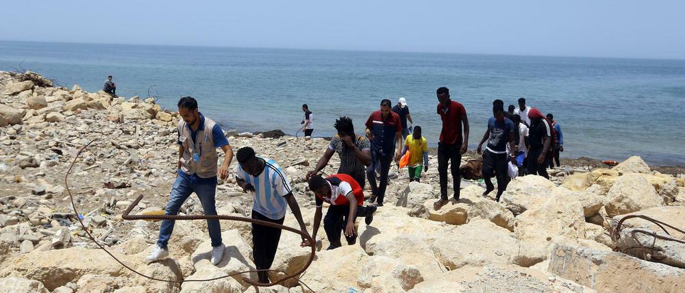 Gerettete Flüchtlinge gehen an der Küste östlich von Tripolis an Land, doch rund 100 Flüchtlinge werden noch vermisst. Am Sonntag kam es zu einem weiteren Bootsunfall. 