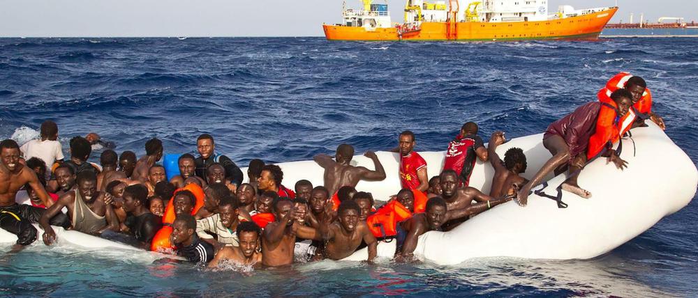 Flüchtlinge sitzen auf dem Mittelmeer in einem sinkenden Schlauchboot. Auch Anfang September gab es wieder ein verheerendes Bootsunglück mit vielen Toten.