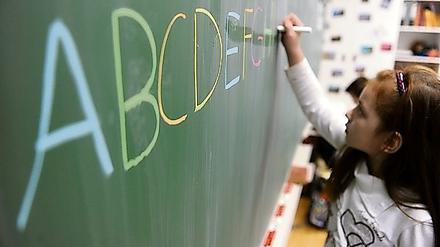 Eine Schülerin schreibt in einer Schule in Hamburg das ABC an die Tafel. 