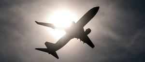 Ein Flugzeug startet vom Flughafen in Düsseldorf und fliegt an der Sonne vorbei. (Symbolbild)