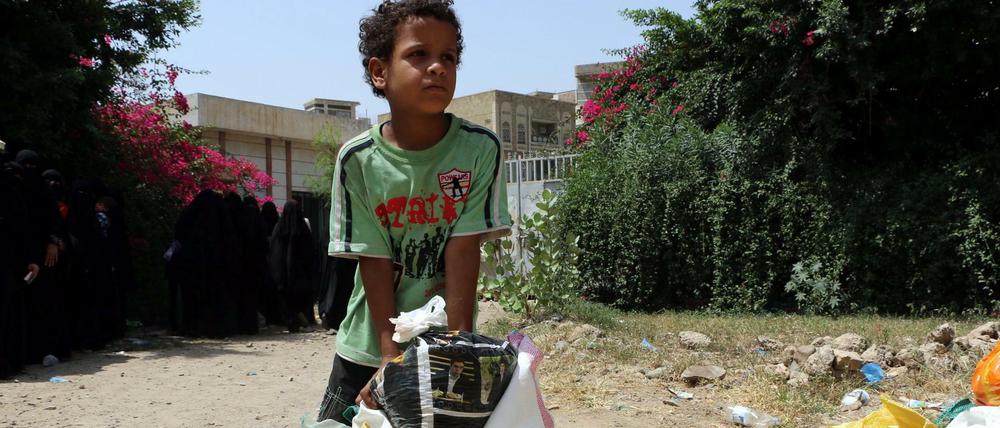 Schwierige Nahrungssuche. Ein kleiner Junge trägt Lebensmittel nach Hause, die von einer Hilfsorganisation im jemenitischen Taiz angeliefert wurden. 