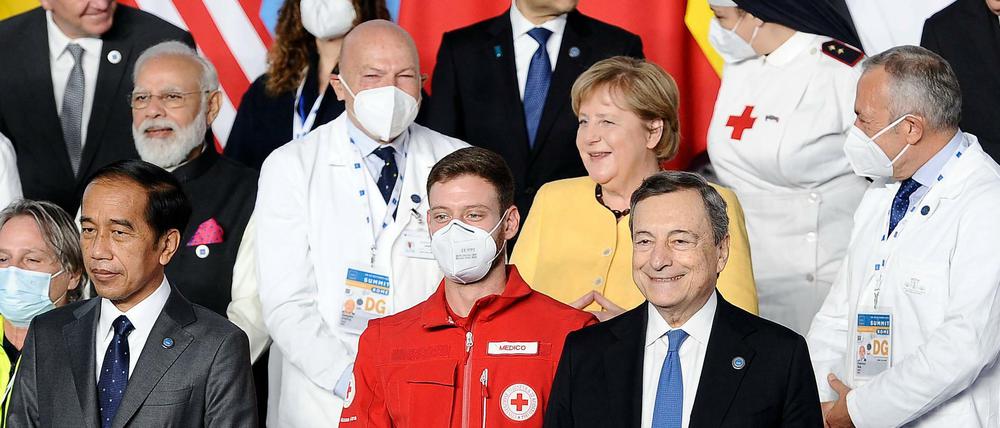 Kanzlerin Angela Merkel zwischen zwei Ärzten auf einem Foto beim G20-Gipfel.