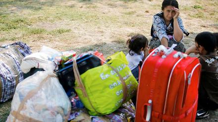 Mit ihrem Gepäck sind Roma am Flughafen in Bukarest angekommen. Frankreich hat weitere 250 Roma abgeschoben.