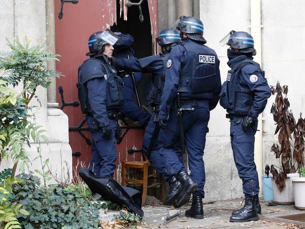 Französische Sicherheitskräfte brechen eine Tür in einer Kirche in Saint-Denis nahe des Einsatzortes auf. Die Hintergründe dafür sind unklar.