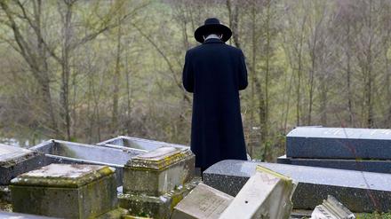 Ein Rabbi steht auf einem jüdischen Friedhof in Frankreich. 