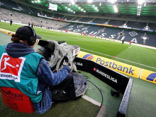 Ein Kameramann filmt das Aufwärmen der Mannschaften im zuschauerfreien Stadion Borussia Park beim Geisterspiel Mönchengladbach gegen den 1. FC Köln im März. 