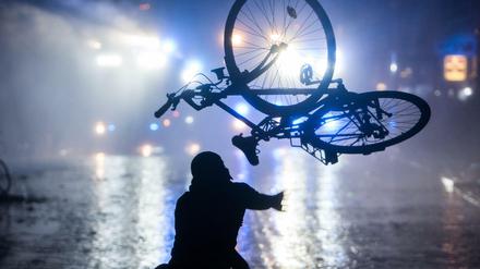 Ein Randalierer wirft in Hamburg im Schanzenviertel ein Fahrrad in Richtung von Wasserwerfern. 