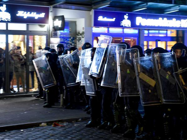 Krawalle im Schanzenviertel: Passanten suchen während einer Polizeiaktion Schutz in einem Restaurant.