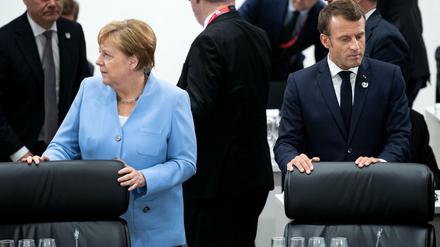 Bundeskanzlerin Angela Merkel (CDU) und Emmanuel Macron, Präsident von Frankreich, stehen zu Beginn der ersten Arbeitssitzung des G20-Gipfels nebeneinander. 