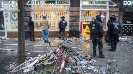 Polizisten stehen am 08.07.2017 in Hamburg im Schanzenviertel vor einem geplünderten Supermarkt.