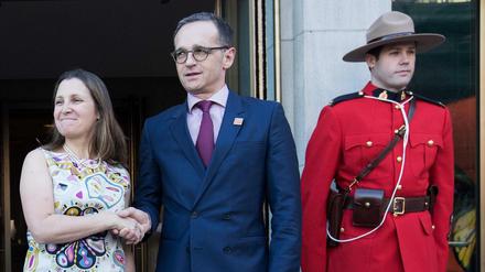 Gut behütet in Toronto: Außenminister Heiko Maas (SPD, Mitte) mit seiner kanadischen Kollegin Chrystia Freeland.