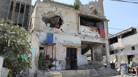 In Trümmern: Die Brüder Musabeh würden gerne die Überreste ihres Hauses verlassen. Aber dafür fehlt ihnen das Geld.
