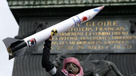 Ein Demonstrant hält eine Rakete mit israelischer Flagge in die Luft.