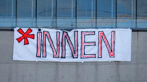 Ein Plakat mit der Aufschrift „*INNEN“ ist an der Hochschule für Fernsehen und Film München zu sehen (Symbolbild).