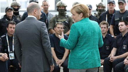 Olaf Scholz und Angela Merkel am Samstag im Gespräch mit Einsatzkräften des Gipfeltreffens.