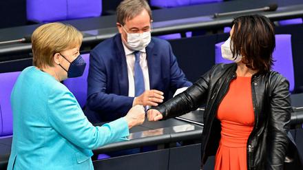 Kanzlerin Angela Merkel, Armin Laschet und Annalena Baerbock begrüßen sich.