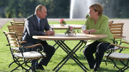 Der russische Präsident Wladimir Putin und Bundeskanzlerin Angela Merkel im Garten von Schloss Meseberg. 