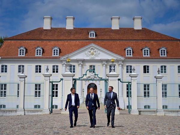 Fast wie die drei Musketiere: Robert Habeck, Olaf Scholz und Christian Lindner (von links) auf dem Weg zur Pressekonferenz vor Schloss Meseberg.