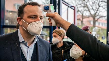 Gesundheitsminister Jens Spahn (CDU) lässt sich vor dem Besuch eines Impfzentrums die Temperatur messen.