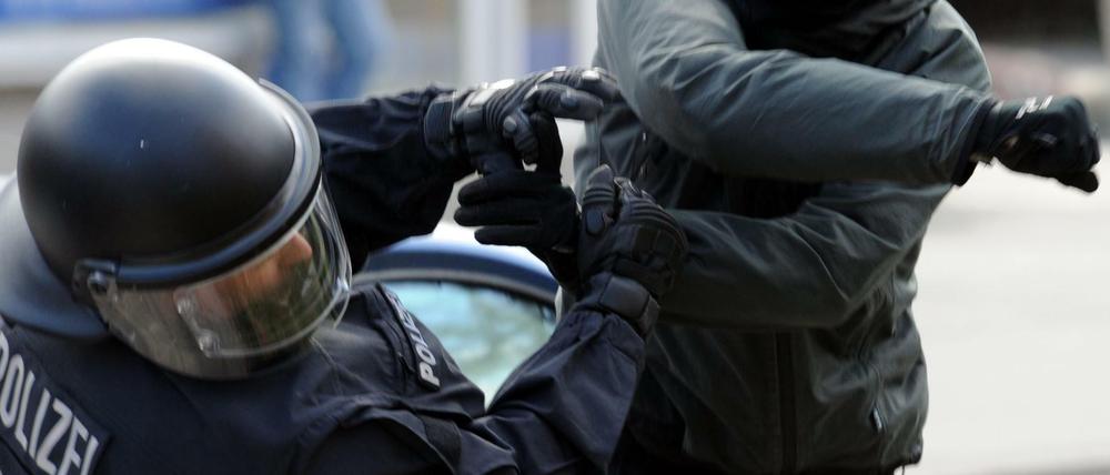 Ein gewalttätiger Demonstrant schlägt einen Polizeibeamten nieder (Archiv). 