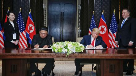 Singapur: U.S. Präsident Donald Trump und der Machthaber von Nordkorea Kim Jong Un unterzeichnen eine gemeinsame Vereinbarung. 