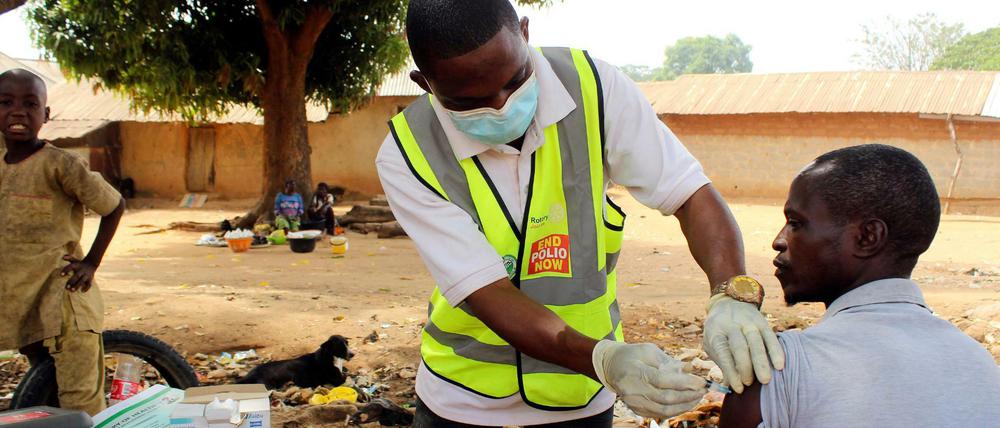 Ein Gesundheitshelfer verabreicht einem Mann den Corona-Impfstoff von AstraZeneca in Sabon Kuje am Rande von Abuja (Nigeria).