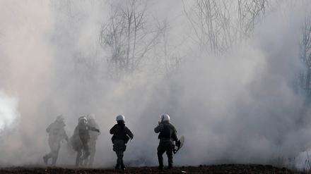 Griechische Bereitschaftspolizisten stehen inmitten von Tränengaswolken in der Nähe des türkischen Grenzübergangs.
