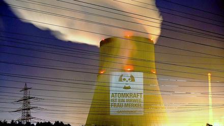 Greenpeace Aktivisten projizieren in Lingen den Schriftzug "Atomkraft ist ein Irrweg, Frau Merkel" auf den Kühlturm des Atomkraftwerkes Emsland. 