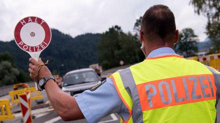 Polizisten kontrollieren an einer mobilen Kontrollstelle kurz hinter der Grenze zu Österreich Fahrzeuge. 