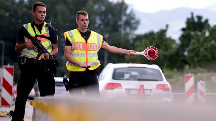 Polizisten kontrollieren Fahrzeuge, die aus Österreich nach Deutschland kommen.