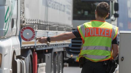 Ein Polizist steht mit einer Kelle an einer Kontrollstelle der Bundespolizei auf der Autobahn 3 in Bayern. 