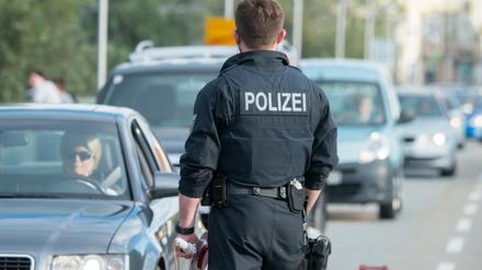 Ein Bundespolizist kontrolliert an der deutsch-österreichischen Grenze im bayerischen Simbach am Inn Fahrzeuge.