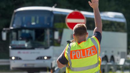 Ein Bundespolizist hält an einer Kontrollstelle an der Autobahn A 3 in Bayern einen Bus an. 