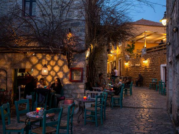 Touristen sitzen in einem Cafe in Areopoli, der Hauptstadt der griechischen Halbinsel Mani.