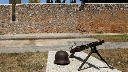 Ein Helm und ein Maschinengewehr, so wie sie von den deutschen Soldaten im Zweiten Weltkrieg benutzt worden sind, im Skopeftirio Park in Athen. Hier wurden 1100 Griechen hingerichtet. 