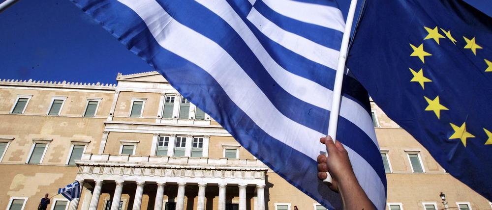 Die griechische Flagge und die EU-Fahnewerden vor dem Parlament hochgehalten. 