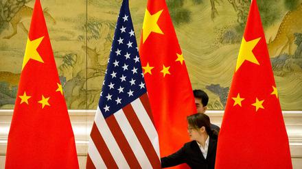 Alte und neue Supermacht: Chinesische Mitarbeiter richten im Rahmen von Handelsgesprächen zwischen China und den USA Flaggen aus. 