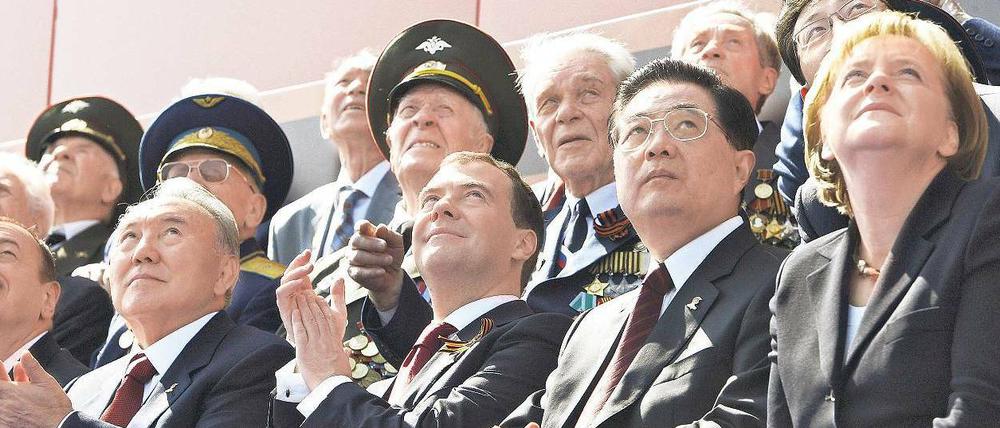 Die da oben. Angela Merkel, Chinas Staatschef Hu Jintau und Russlands Präsident Dmitri Medwedew beobachten während der Parade Fliegerformationen der russischen Luftwaffe.