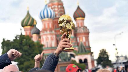 Gold, was glänzt. Auf dem Roten Platz in Moskau feiern Fußballfans schon Tage vor Beginn der WM mit einer Pokalattrappe. 