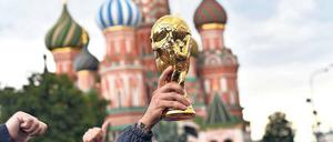 Gold, was glänzt. Auf dem Roten Platz in Moskau feiern Fußballfans schon Tage vor Beginn der WM mit einer Pokalattrappe. 