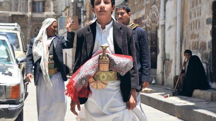 Mit Krummdolch und Gebetsteppich: Dieser junge Mann in der Hauptstadt Sanaa repräsentiert den sittenstrengen, tribalen Norden. Im ehemaligen sozialistischen Süden war das Bildungsniveau höher und die Gleichberechtigung weit verbreitet.