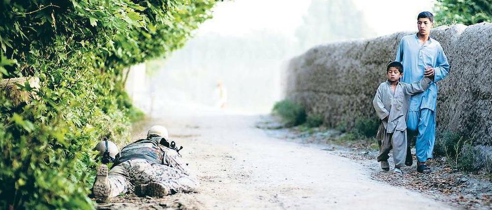 Klima der Angst. Ein Bundeswehrsoldat sichert bei Kundus einen Weg, auf dem Dorfbewohner entlanggehen. 