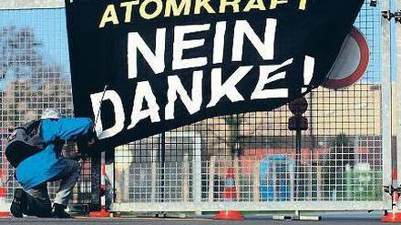 Protest. Eine Aktivistin hängt ein Banner vor dem Zwischenlager in Ahaus auf. Foto: dpa