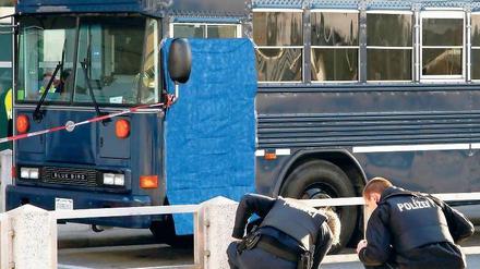 Am Tatort. Polizisten suchen vor dem US-Militärbus nach Spuren. Foto: dapd
